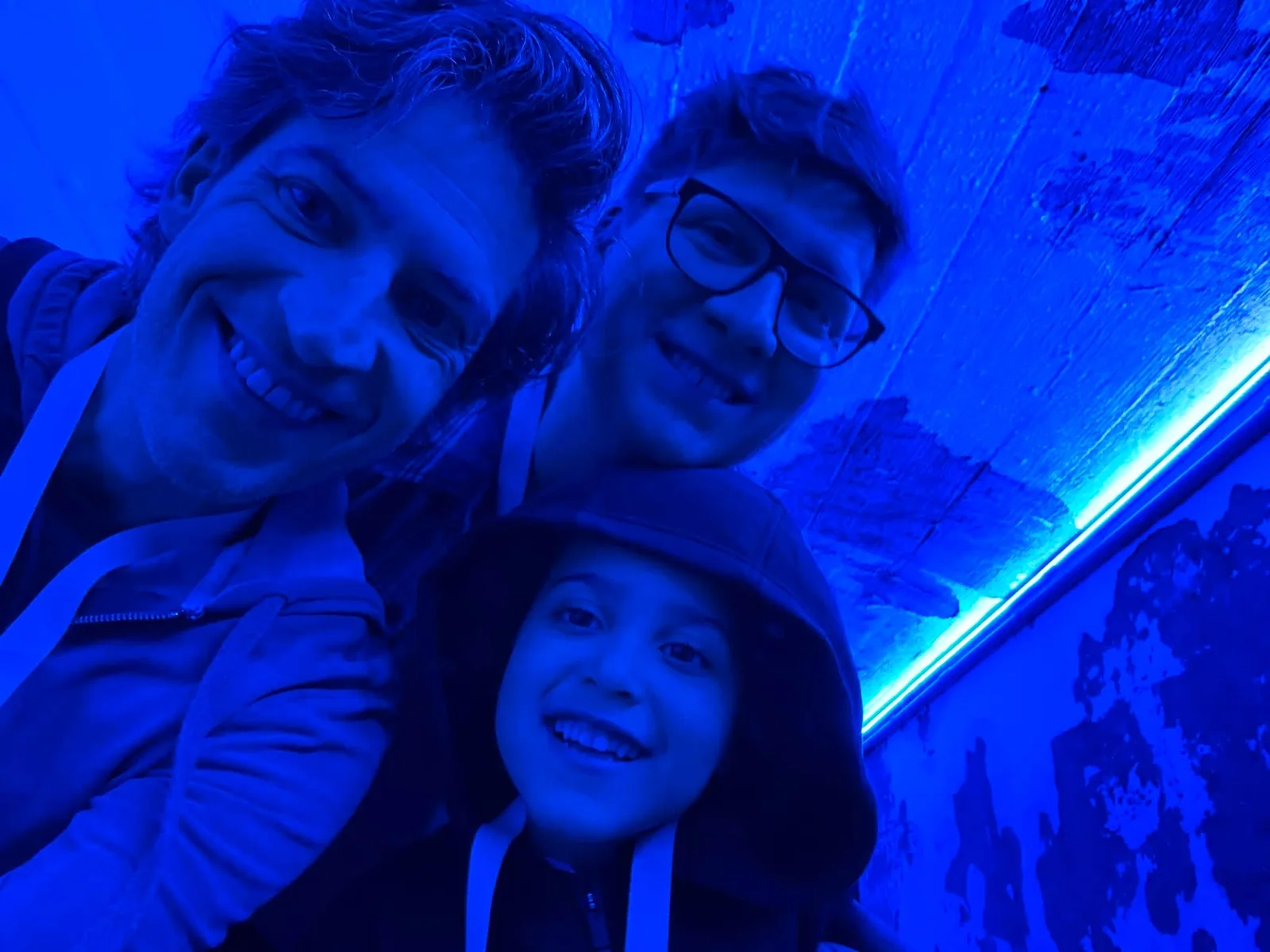 A family portrait under vivid blue light.